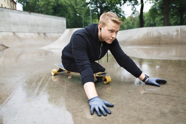 Jonge en gemotiveerde gehandicapte man met een longboard in een skatepark