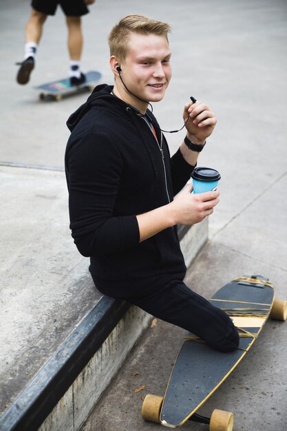 Jonge en gemotiveerde gehandicapte man met een longboard in het skatepark