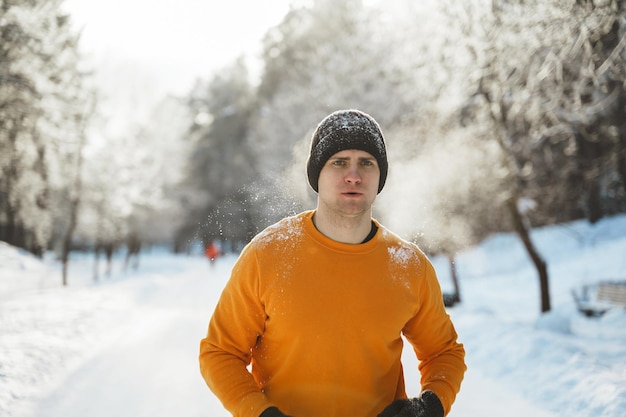 Jonge en knappe jogger tijdens zijn training in het winterpark