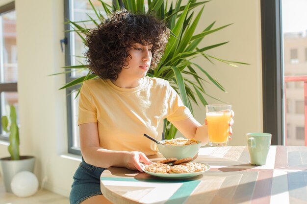 Jonge en mooie Arabische vrouw die thuis een ontbijt heeft.