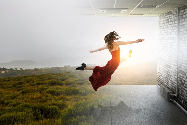 Foto jonge en mooie danseres in een rode jurk in een sprong. gemengde media