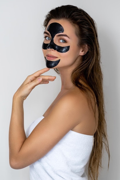 Foto jonge en mooie vrouw met een zwart afneembare masker op haar gezicht.