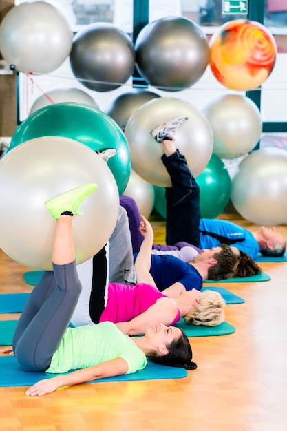 Jonge en senior mensen trainen met de bal in de sportschool