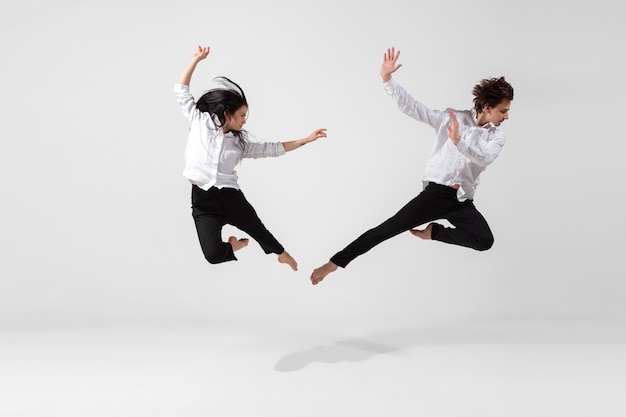 Jonge en sierlijke balletdansers in minimale zwarte stijl geïsoleerd op een witte studio achtergrond