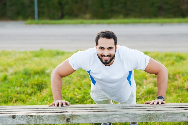 Jonge en sportieve man die buiten traint in sportkleding