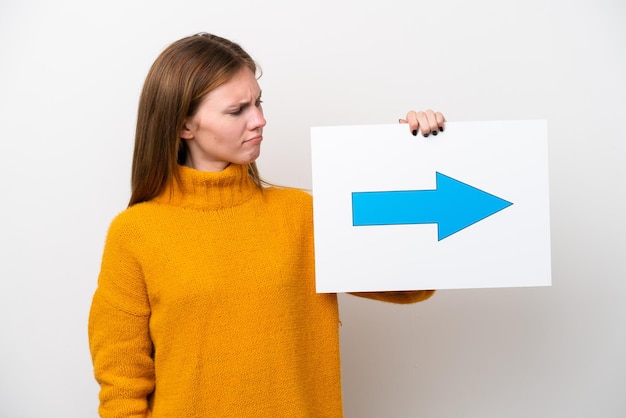 Jonge Engelse die vrouw op witte achtergrond wordt geïsoleerd die een plakkaat met pijlsymbool houdt