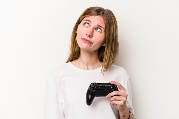 Jonge Engelse vrouw die met een videogamecontroller speelt, isoleert een witte achtergrond die droomt van het bereiken van doelen en doeleinden