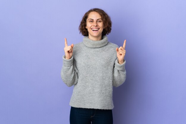 Jonge Engelse vrouw die op paarse achtergrond wordt geïsoleerd die een geweldig idee benadrukt