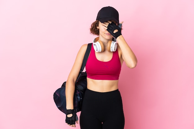 Jonge Engelse vrouw die op roze muur wordt geïsoleerd die ogen behandelt door handen. Ik wil niets zien