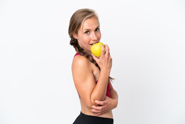 Jonge Engelse vrouw die op witte achtergrond een appel eet