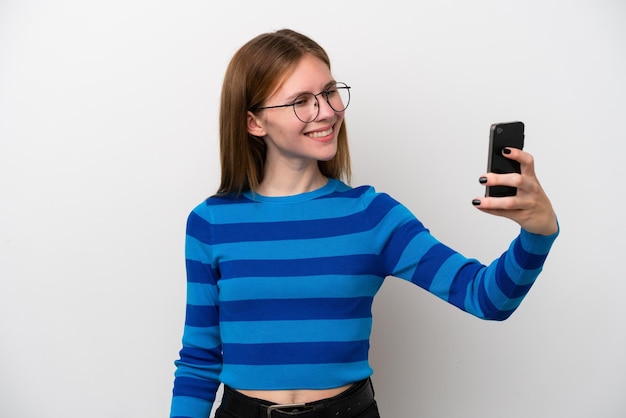 Jonge Engelse vrouw die op witte achtergrond wordt geïsoleerd die een selfie maakt