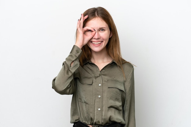 Jonge Engelse vrouw die op witte achtergrond wordt geïsoleerd die ok teken met vingers toont