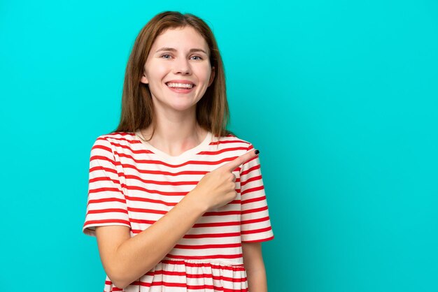 Jonge Engelse vrouw geïsoleerd op een blauwe achtergrond die naar de zijkant wijst om een product te presenteren