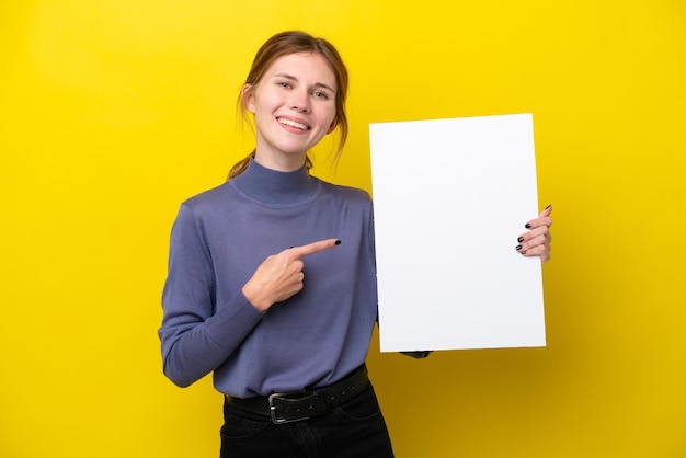 Jonge Engelse vrouw geïsoleerd op een gele achtergrond met een leeg bordje met een gelukkige uitdrukking en erop wijzend