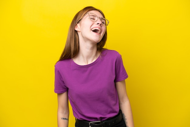 Jonge Engelse vrouw geïsoleerd op gele achtergrond lachen