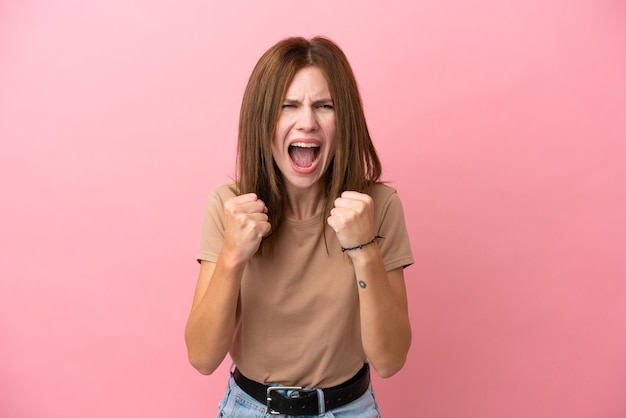 Jonge Engelse vrouw geïsoleerd op roze achtergrond gefrustreerd door een slechte situatie