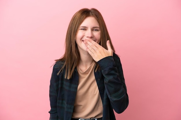 Jonge Engelse vrouw geïsoleerd op roze achtergrond gelukkig en glimlachend die mond bedekken met hand