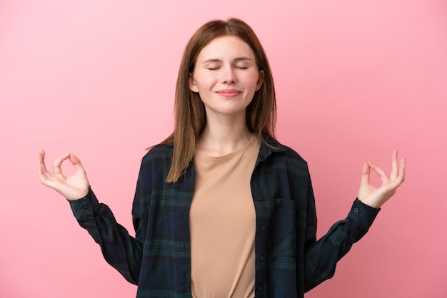 Jonge Engelse vrouw geïsoleerd op roze achtergrond in zen pose