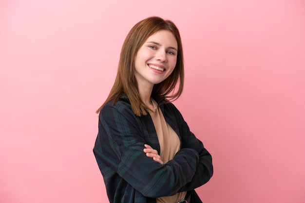 Jonge Engelse vrouw geïsoleerd op roze achtergrond met gekruiste armen en vooruitkijkend