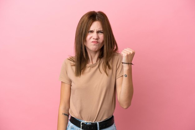 Jonge Engelse vrouw geïsoleerd op roze achtergrond met ongelukkige expressie