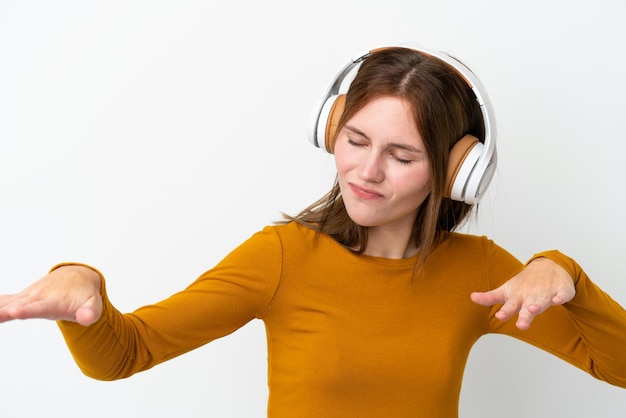 Jonge Engelse vrouw geïsoleerd op witte achtergrond muziek luisteren en dansen