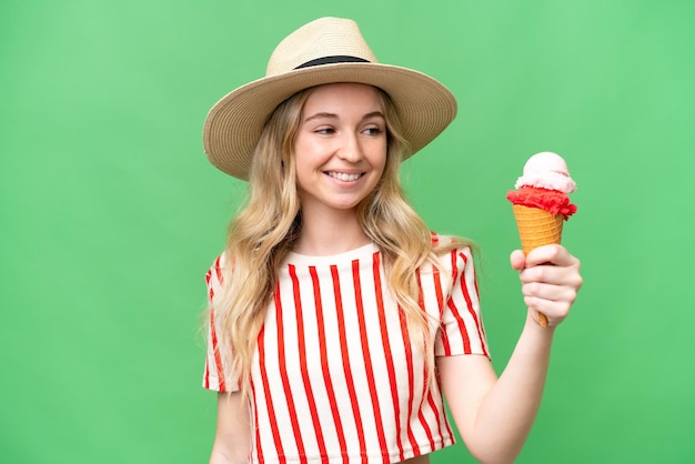 Jonge Engelse vrouw met een cornetroomijs over geïsoleerde achtergrond met gelukkige uitdrukking