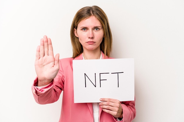 Foto jonge engelse vrouw met een nft-plakkaat geïsoleerd op een witte achtergrond, staande met uitgestrekte hand met stopbord dat je verhindert