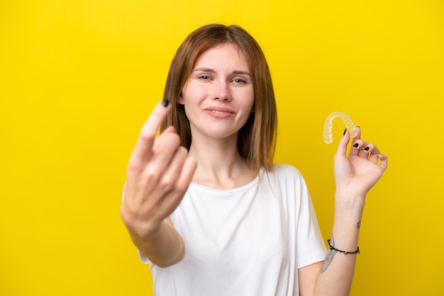 Jonge engelse vrouw met onzichtbare beugels die komend gebaar maken