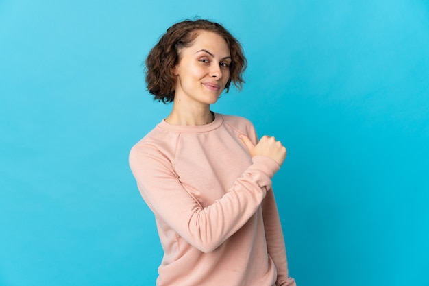 Jonge Engelse vrouw op blauw, trots en zelfvoldaan