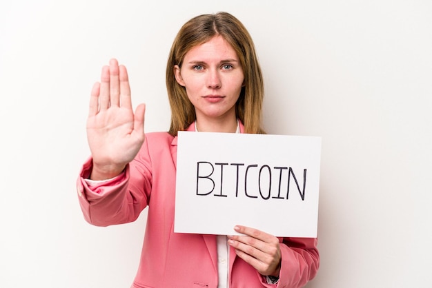 Jonge engelse zakenvrouw met een bitcoin-plakkaat geïsoleerd op een witte achtergrond, staande met uitgestrekte hand met stopbord dat u verhindert