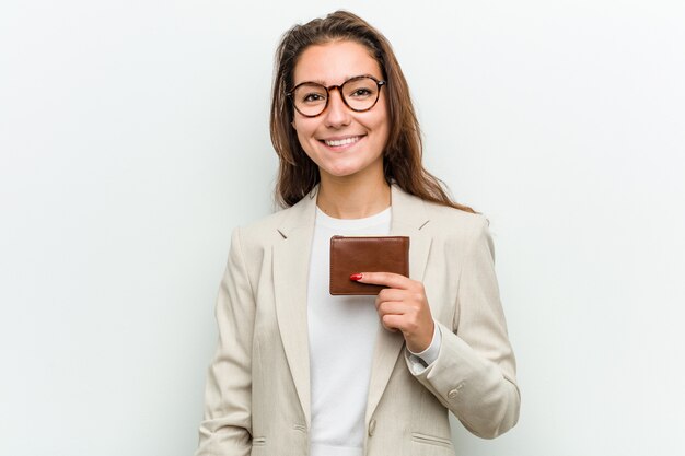 Jonge europese bedrijfsvrouw die een portefeuille gelukkig, glimlachend en vrolijk houdt.