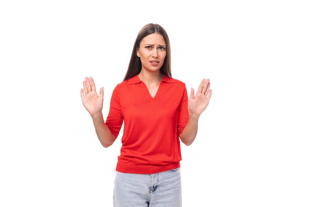 jonge Europese vrouw met zwart haar gekleed in een rood T-shirt op een witte achtergrond met kopieerruimte