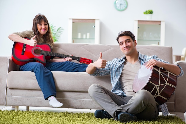 Jonge familie die thuis muziek zingt en speelt