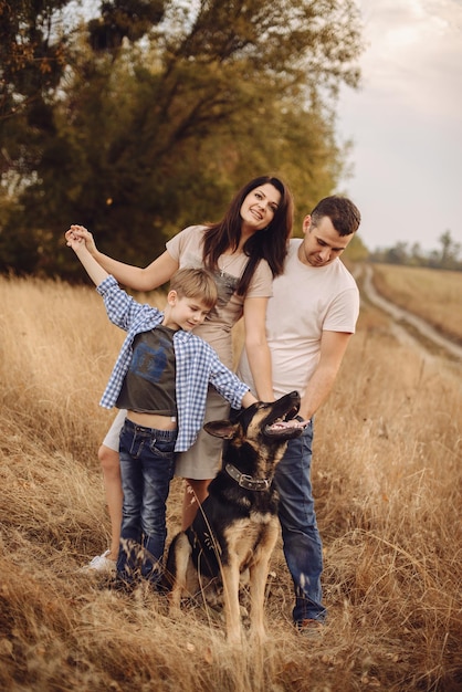 Jonge familie en hun hond brengen tijd door in de natuur in de herfstmiddag