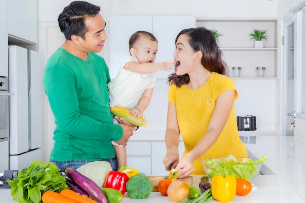 Jonge familie groentesalade maken in de keuken