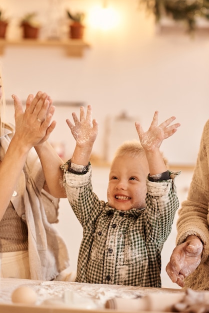 Jonge familie vader, moeder en hun zoontje hebben plezier met spelen en koken in de keuken