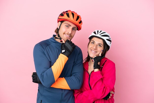 Jonge fietser blanke mensen geïsoleerd op roze achtergrond glimlachend met een lieve uitdrukking