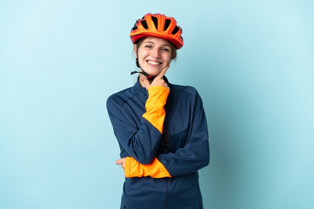 Jonge fietser vrouw geïsoleerd op blauw blij en lachend