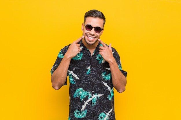 Jonge filipijnse man draagt zomer kleding glimlach, wijzende vingers op mond.