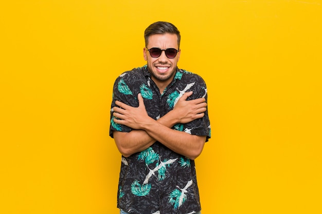 Jonge Filipijnse man draagt zomerkleding koud als gevolg van lage temperatuur of een ziekte