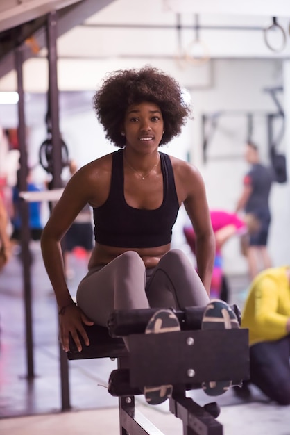 jonge fit Afro-Amerikaanse vrouw doet sit-ups in de fitnessstudio in de sportschool. Buikoefeningen Sit up