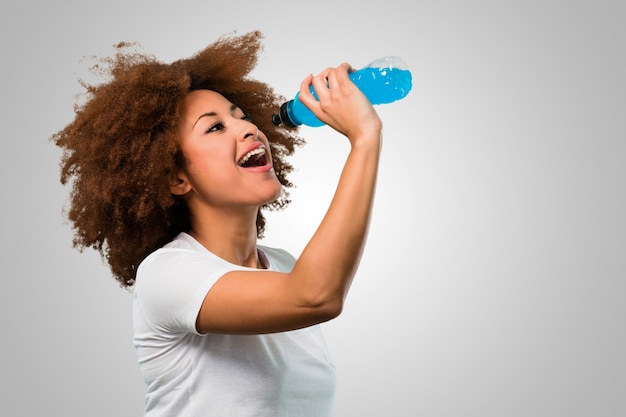 Jonge fitness afro vrouw die een energiedrank drinkt