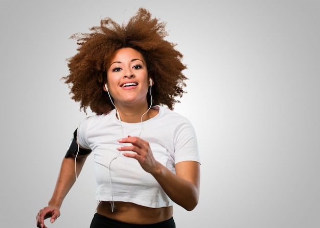 Jonge fitness afro vrouw joggen en luisteren naar muziek