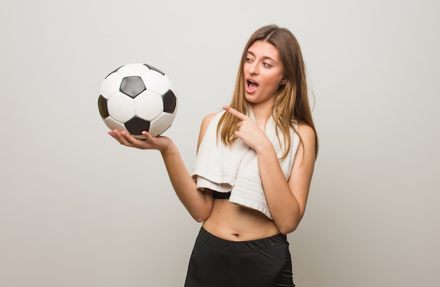 Jonge fitness Russische vrouw die aan de kant richt. Een voetbal vasthouden.