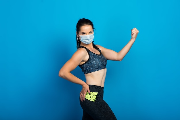 Jonge fitness vrouw in een gezichtsmasker uit te werken