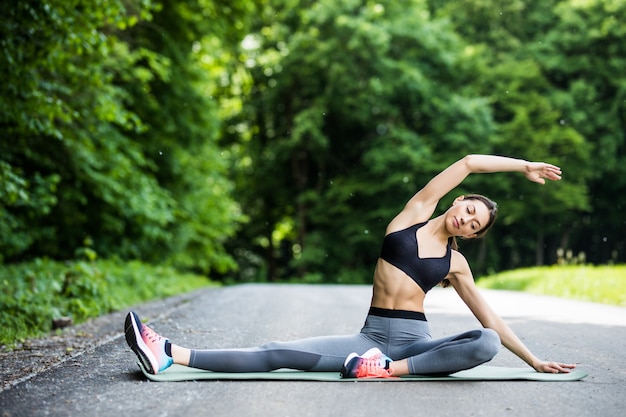 Jonge fitness vrouw runner benen strekken voordat uitgevoerd in het stadspark