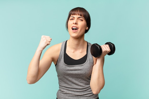 Jonge fitnessvrouw met een dumbbell