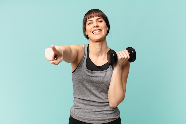 Jonge fitnessvrouw met een dumbbell