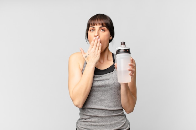 Jonge fitnessvrouw met een waterkan