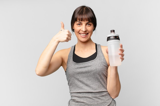 Jonge fitnessvrouw met een waterkan